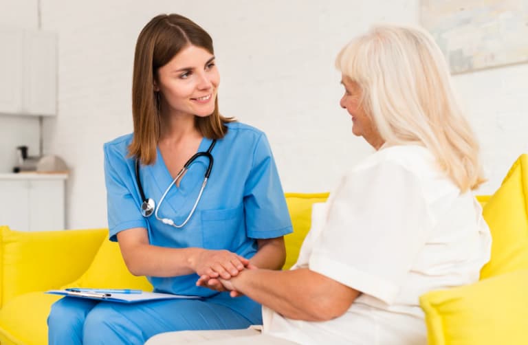 A nurse treating an elderly woman